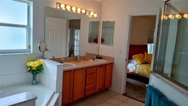 bathroom with vanity, tile patterned floors, a wealth of natural light, and tiled tub