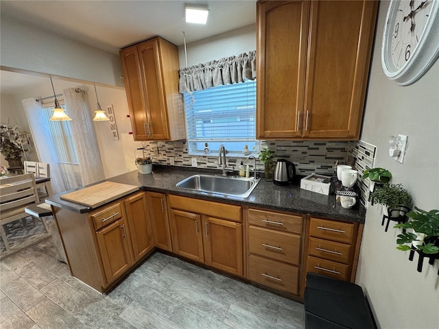 kitchen with pendant lighting, sink, tasteful backsplash, and kitchen peninsula