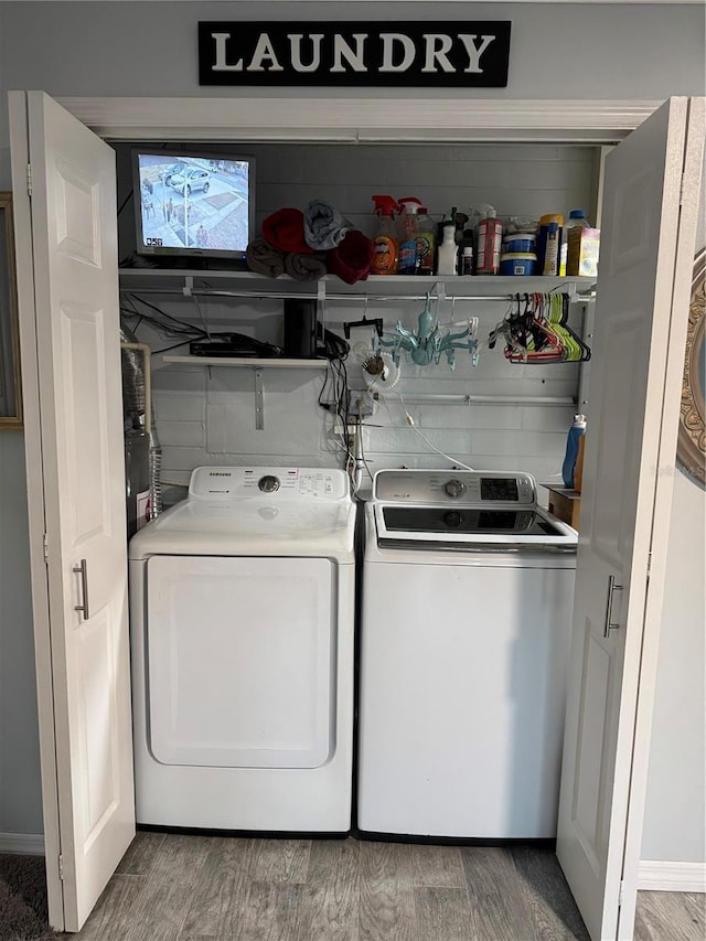 washroom with wood-type flooring and independent washer and dryer