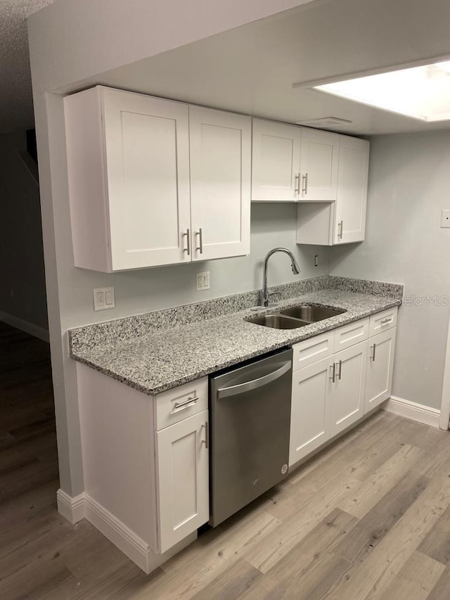 kitchen featuring dishwasher, white cabinets, light hardwood / wood-style floors, and sink