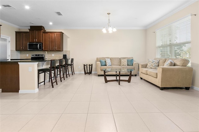 living room featuring a chandelier, crown molding, and light tile patterned flooring