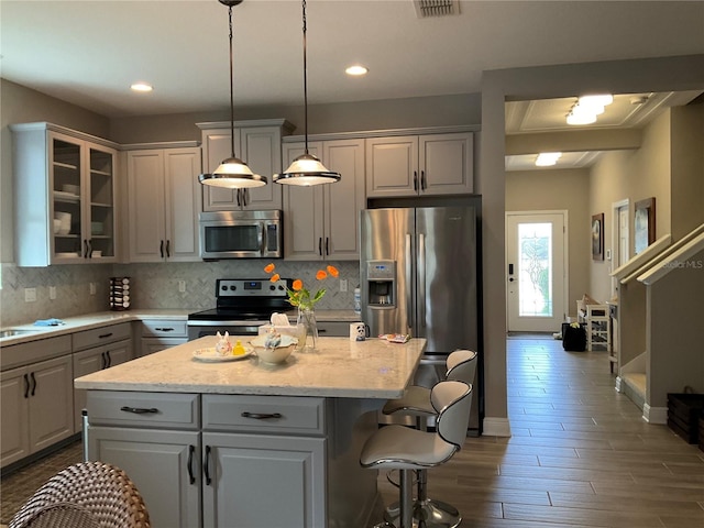 kitchen featuring gray cabinetry, a kitchen island, and appliances with stainless steel finishes