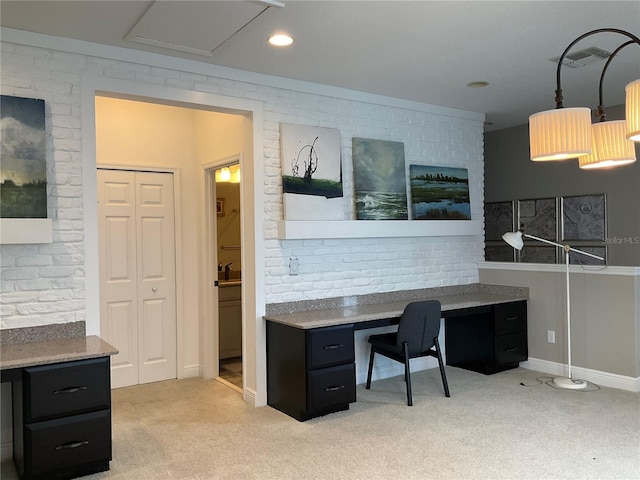 office space with light colored carpet and brick wall