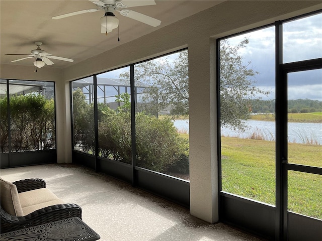 sunroom featuring a water view and ceiling fan