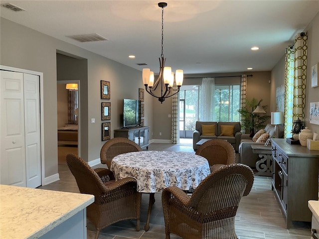 dining area featuring wood-type flooring and an inviting chandelier