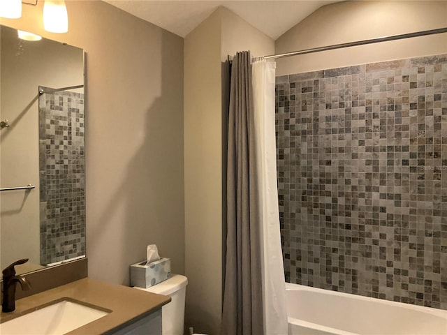 full bathroom featuring vanity, shower / bath combination with curtain, vaulted ceiling, and toilet