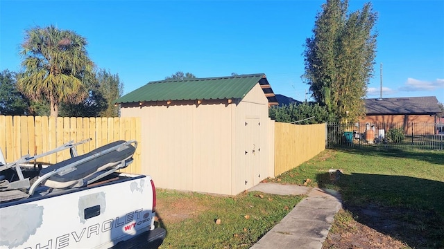 view of side of property featuring a yard and a shed