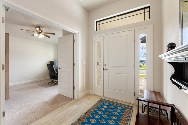 carpeted foyer with ceiling fan