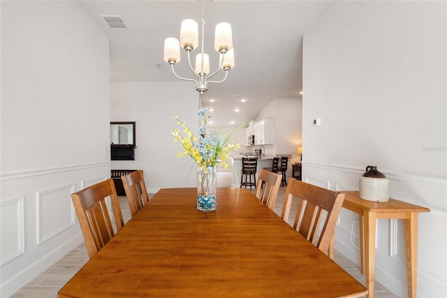 dining room featuring light hardwood / wood-style flooring and a chandelier