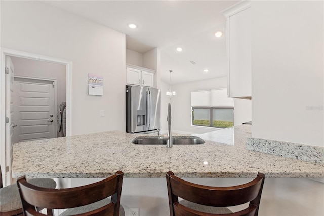 kitchen with white cabinetry, kitchen peninsula, and stainless steel fridge with ice dispenser