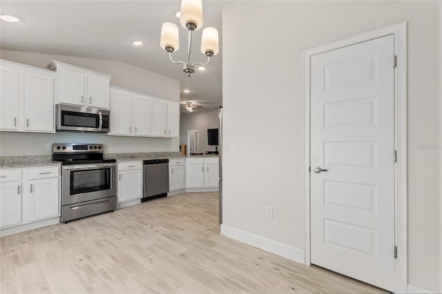 kitchen featuring white cabinetry, stainless steel appliances, and decorative light fixtures