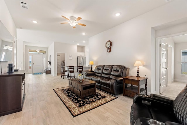 living room with light hardwood / wood-style floors and ceiling fan