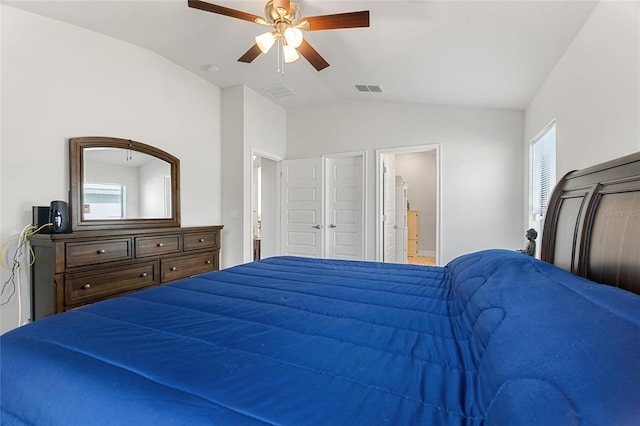 bedroom featuring ceiling fan, lofted ceiling, and ensuite bath