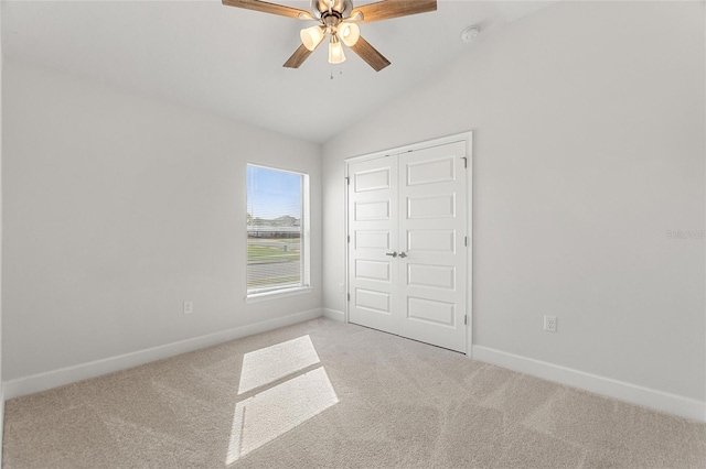 unfurnished bedroom with ceiling fan, lofted ceiling, light carpet, and a closet