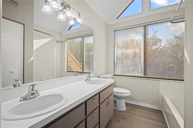 bathroom featuring lofted ceiling, a textured ceiling, toilet, vanity, and hardwood / wood-style flooring