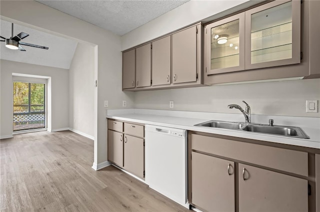 kitchen with white dishwasher, sink, ceiling fan, light wood-type flooring, and a textured ceiling