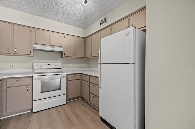 kitchen featuring a textured ceiling, light hardwood / wood-style floors, and white appliances