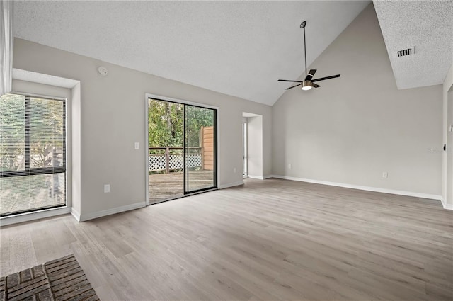 unfurnished living room featuring a textured ceiling, light wood-type flooring, ceiling fan, and a healthy amount of sunlight