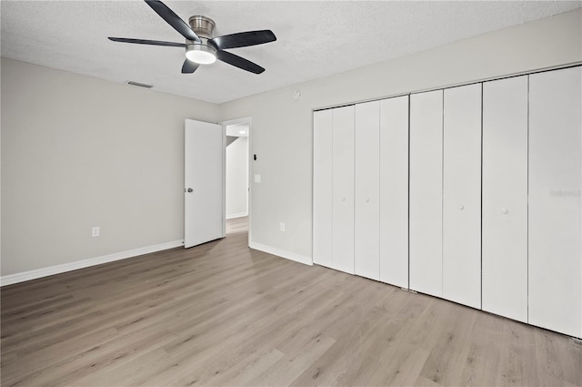 unfurnished bedroom featuring a textured ceiling, light hardwood / wood-style flooring, and ceiling fan