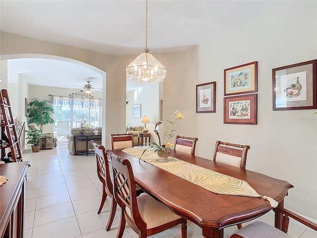 tiled dining space featuring ceiling fan with notable chandelier