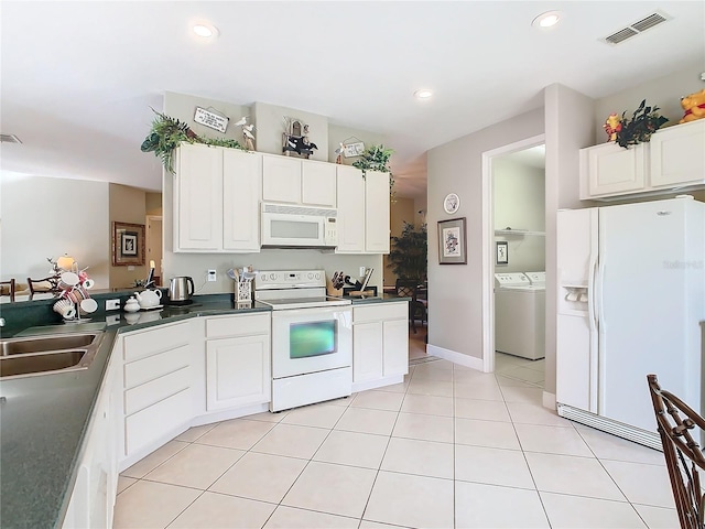 kitchen featuring sink, light tile patterned floors, white appliances, washing machine and clothes dryer, and white cabinets