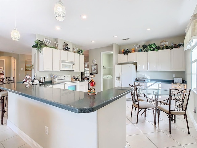 kitchen featuring light tile patterned flooring, pendant lighting, white cabinets, and white appliances