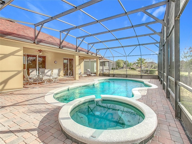 view of swimming pool with a lanai, ceiling fan, a patio, and an in ground hot tub