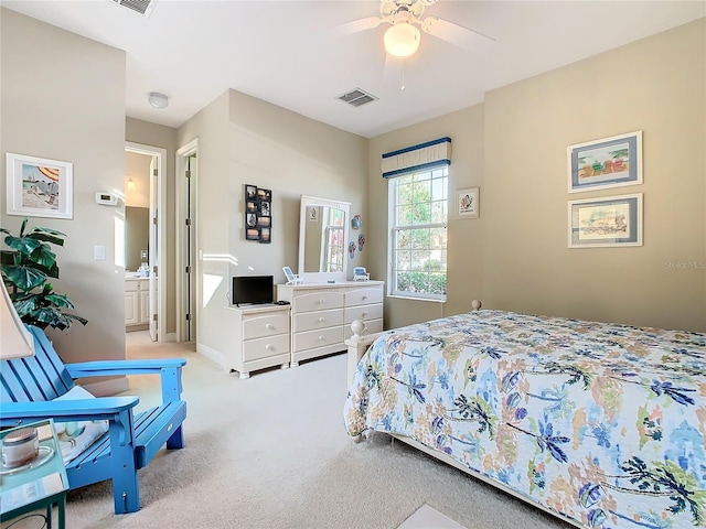 bedroom with light carpet, ceiling fan, and ensuite bath