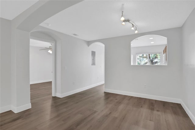 unfurnished room with electric panel, ceiling fan, and dark wood-type flooring