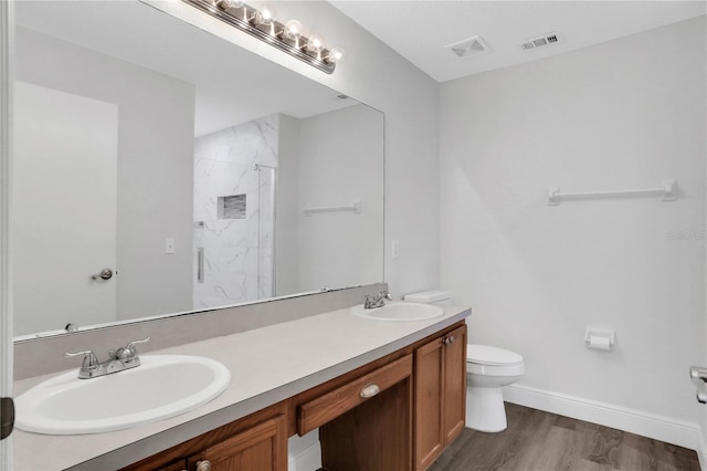 bathroom featuring hardwood / wood-style floors, vanity, toilet, and a shower with shower door