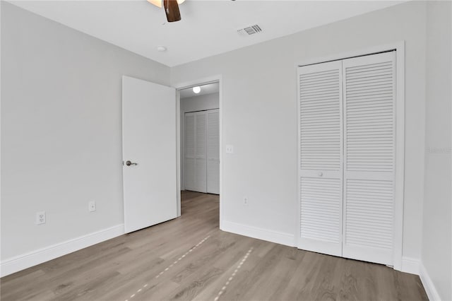 unfurnished bedroom with a closet, light hardwood / wood-style floors, and ceiling fan