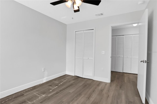 unfurnished bedroom featuring ceiling fan and dark wood-type flooring