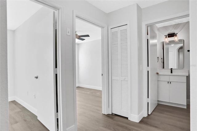 hallway featuring light wood-type flooring and sink