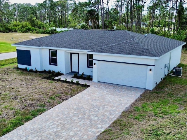 single story home featuring a garage and cooling unit