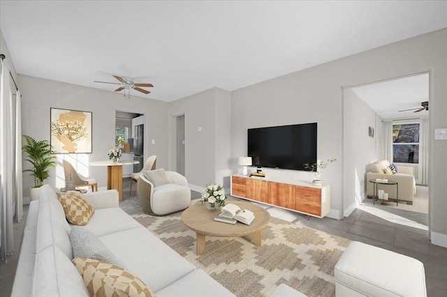 living room featuring a ceiling fan and plenty of natural light