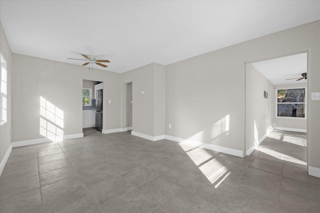 unfurnished room with baseboards and a ceiling fan