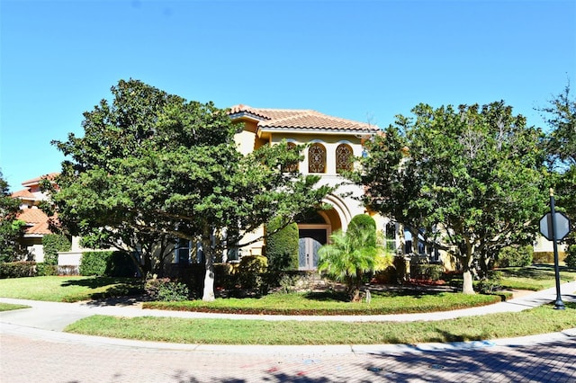 mediterranean / spanish house featuring a front yard