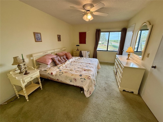 bedroom featuring a textured ceiling, carpet floors, and ceiling fan