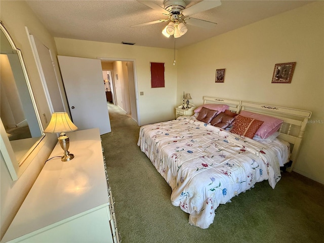 bedroom with ceiling fan, a textured ceiling, and dark colored carpet