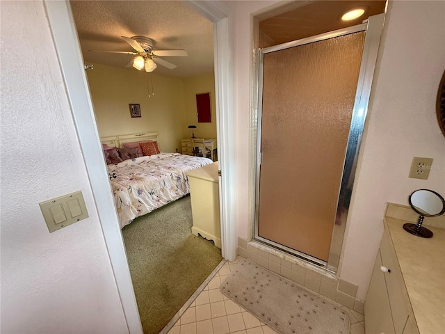 bedroom featuring ceiling fan, light tile patterned floors, and a textured ceiling