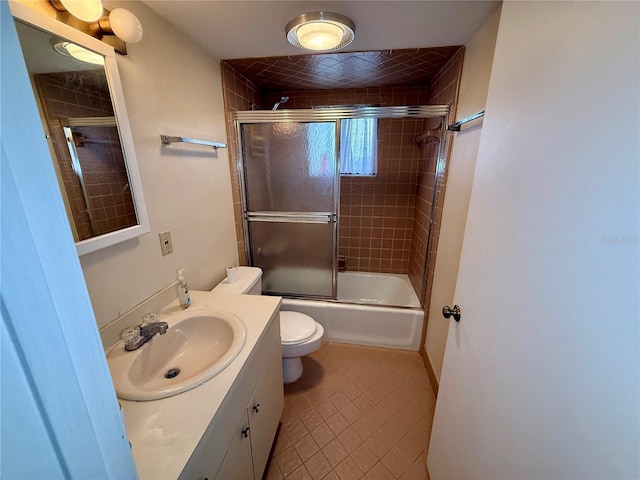 full bathroom with tile patterned floors, vanity, toilet, and bath / shower combo with glass door