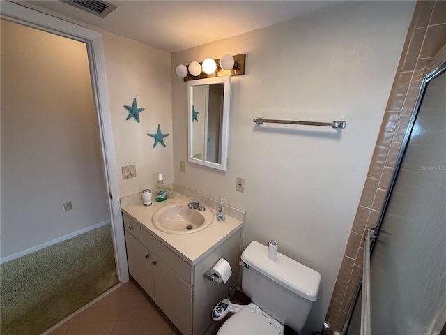 bathroom with tile patterned floors, vanity, toilet, and walk in shower