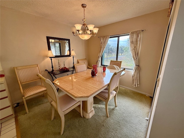 dining area with carpet, a textured ceiling, and an inviting chandelier