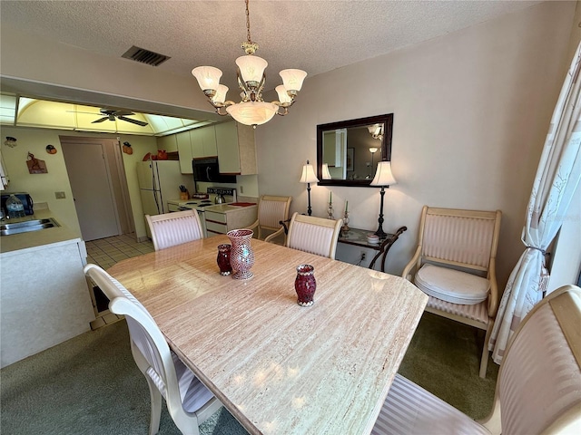 dining room featuring ceiling fan with notable chandelier, sink, and a textured ceiling