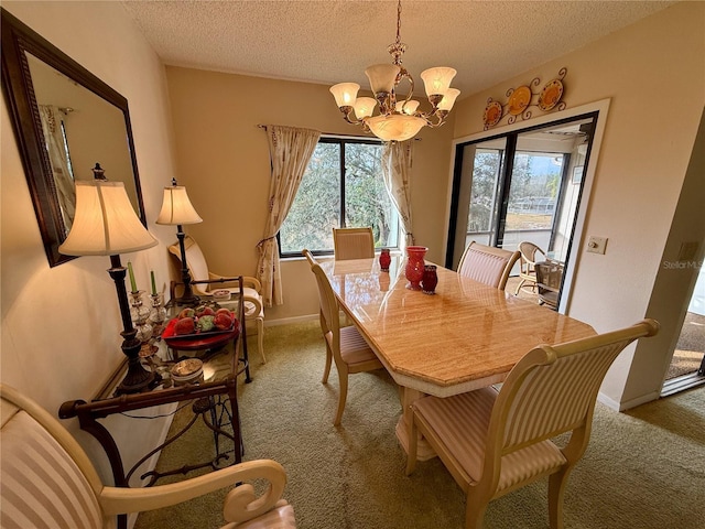 dining space with a chandelier, a textured ceiling, light colored carpet, and plenty of natural light