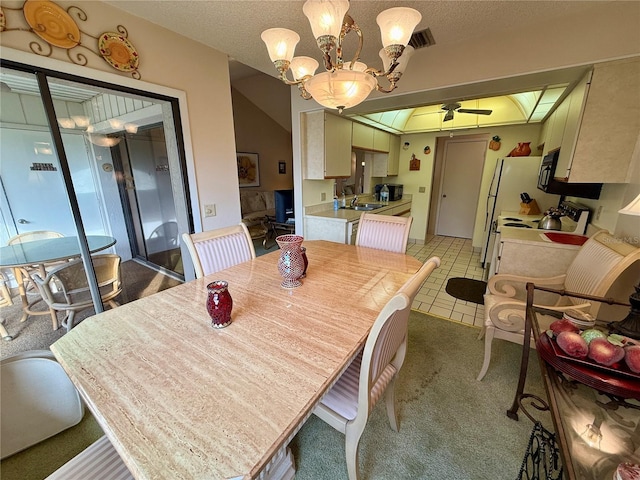 dining space with a textured ceiling, ceiling fan with notable chandelier, tile patterned floors, and sink