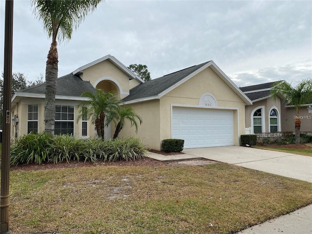 ranch-style house with a garage and a front yard