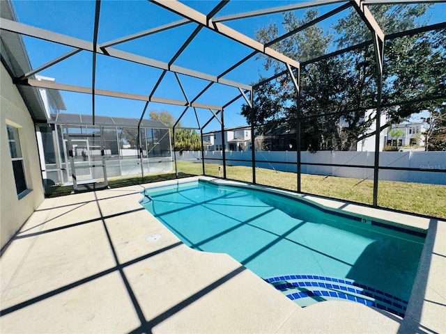 view of swimming pool with a yard, glass enclosure, and a patio area