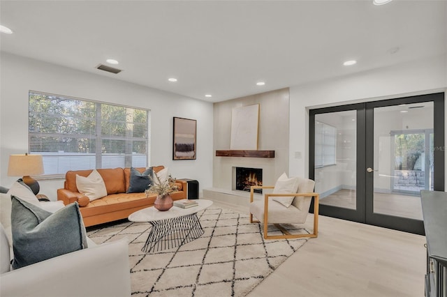 living room featuring french doors and light hardwood / wood-style flooring