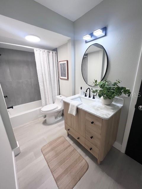 full bathroom with shower / bath combo with shower curtain, vanity, and toilet